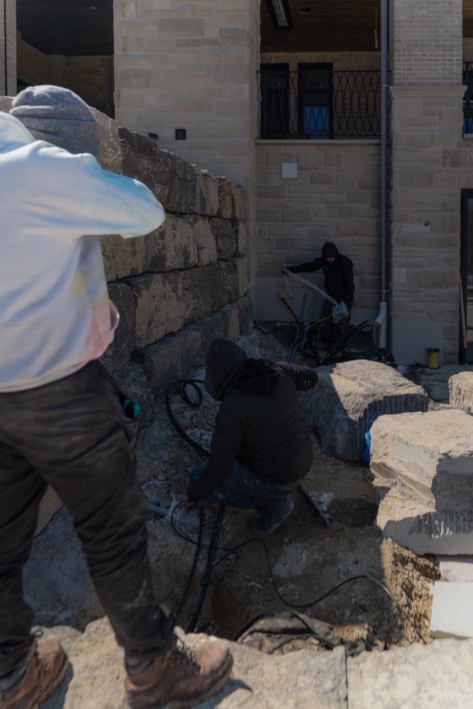 AVAS crew running cabling at a luxury stone home