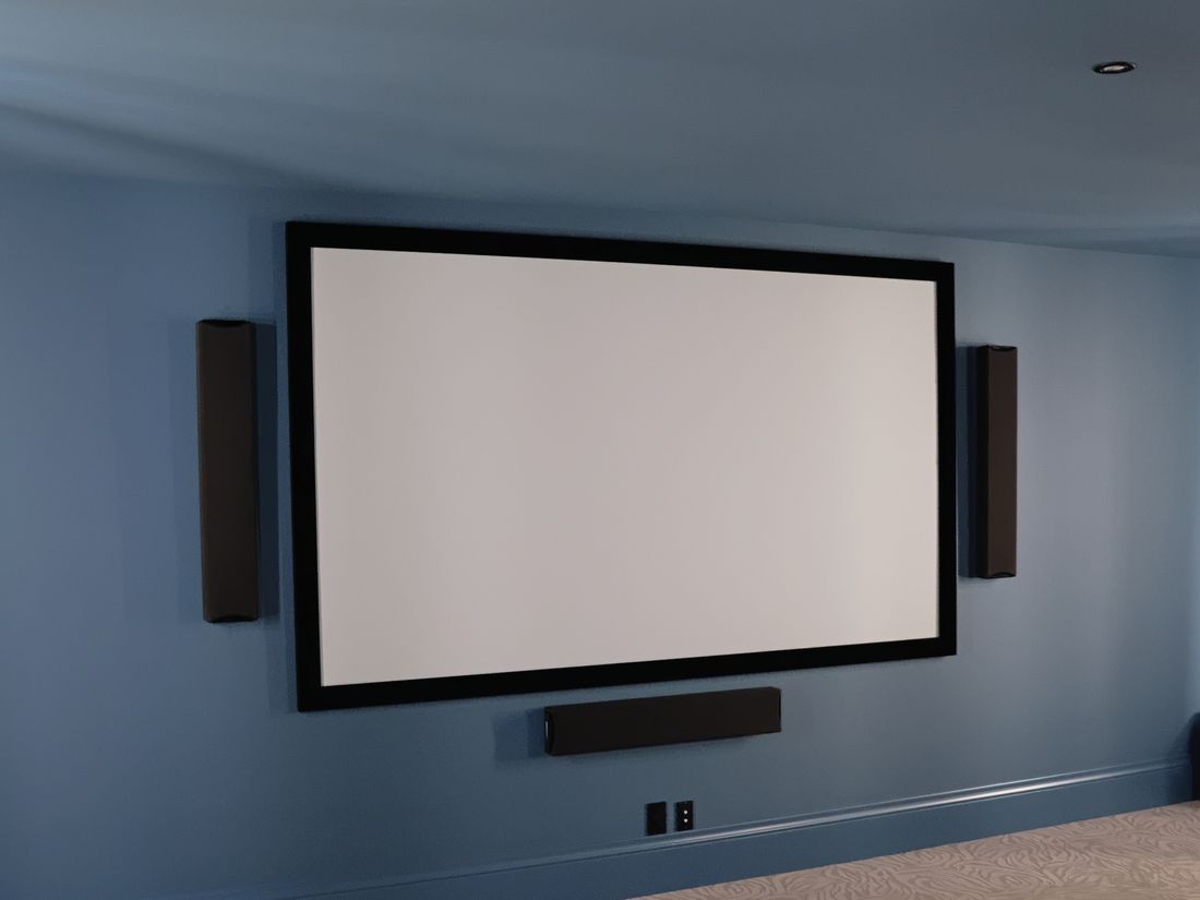 A dedicated home theatre with front speakers around a projector screen
