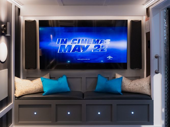 The theatre and lounge inside the AVAS home automation trailer, with a large screen and designer speakers