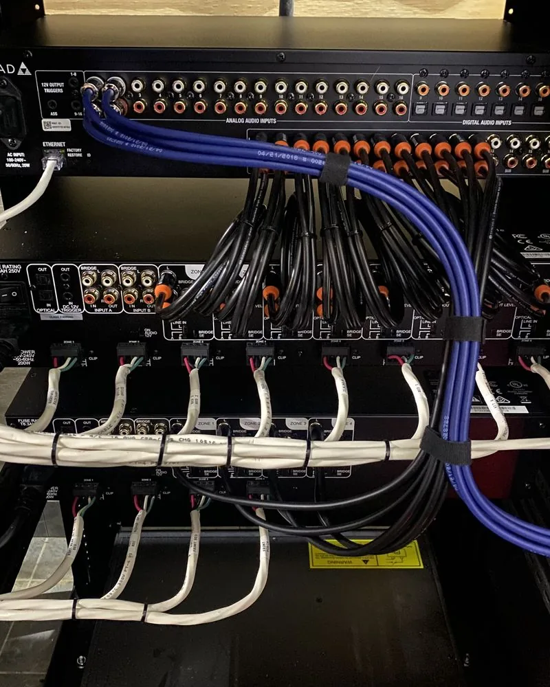 The back of an amplifier with every speaker cable tied and routed