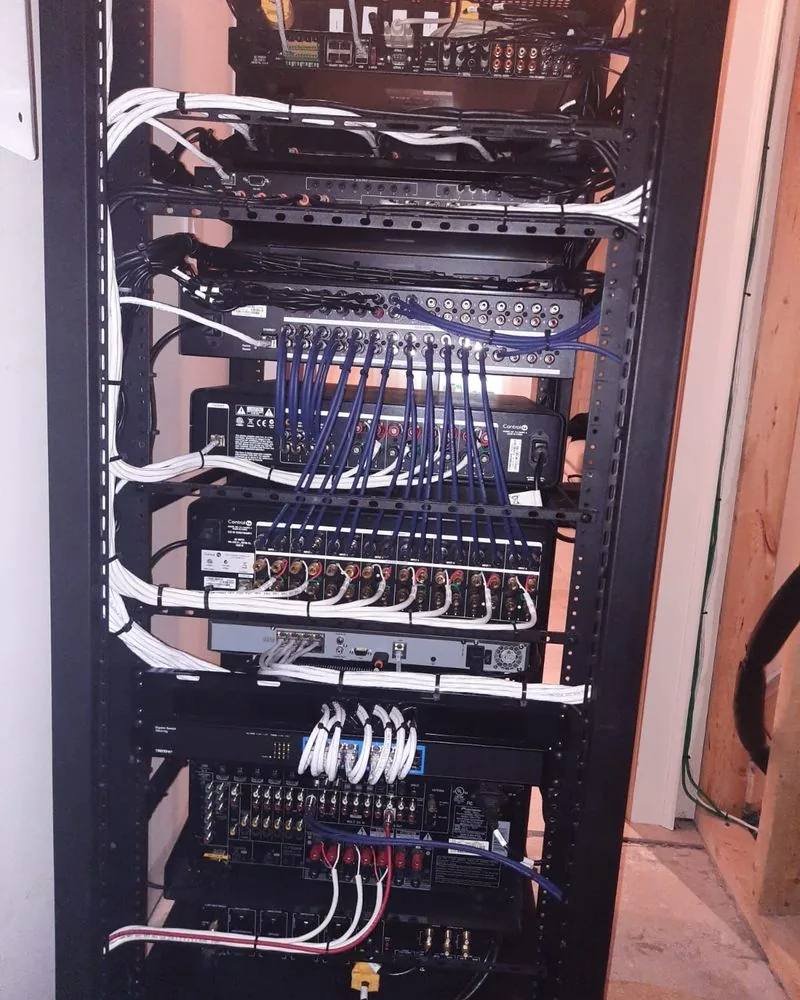 A finished rack inside a framed closet with labelled patch panels