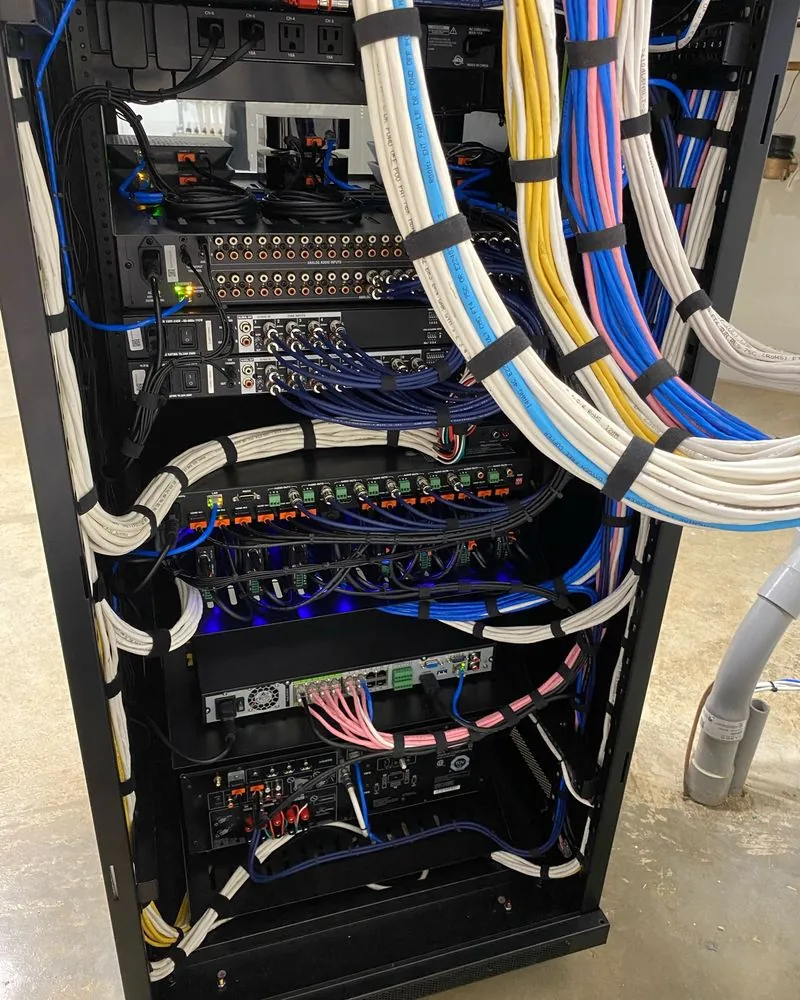 The back of a rack with blue and white cables bundled and tied