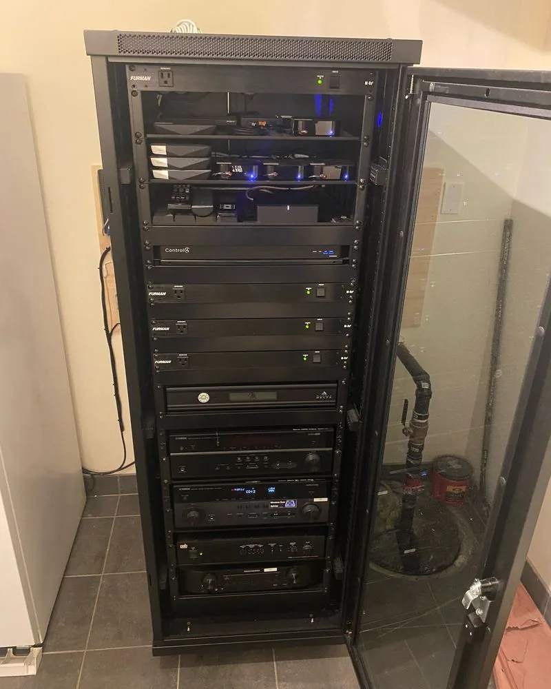 A finished equipment rack behind a glass door